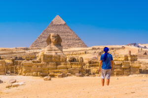 मिस्र के पिरामिड्स, A young man walking towards the Great Sphinx of Giza and in the background the pyramid of Khafre,